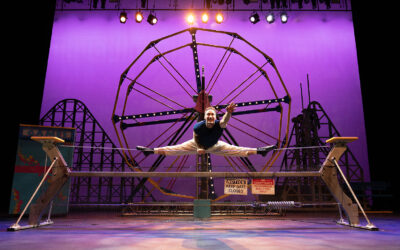 Performer straddling a wire in the Cirque Mechanics: Tilt! performance