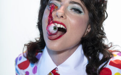 Comedian Sarah Sherman catching a fake eyeball falling from her eye socket onto her tongue