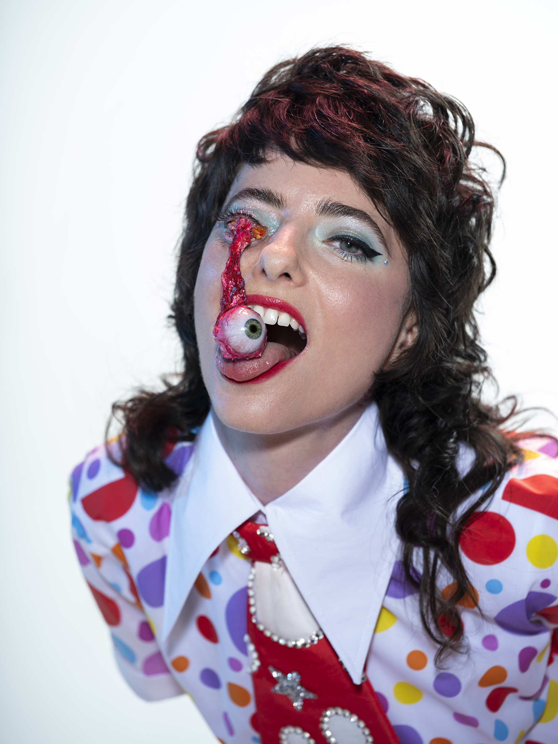 Comedian Sarah Sherman catching a fake eyeball falling from her eye socket onto her tongue