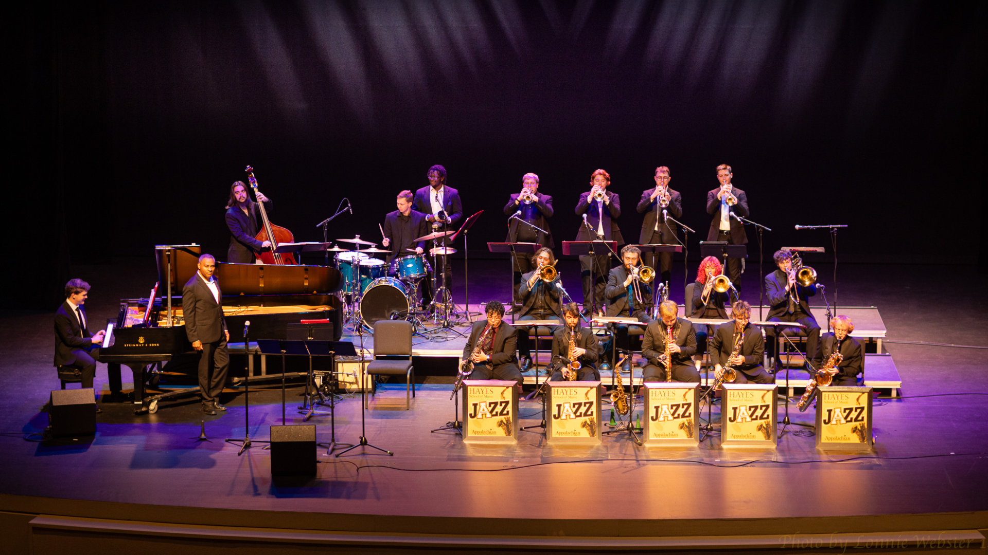 18 student jazz musicians playing sax, horns, drums, and piano